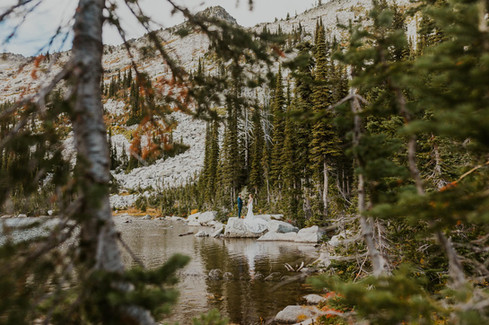 a couple saying their private vows in the mountains by an alpine lake