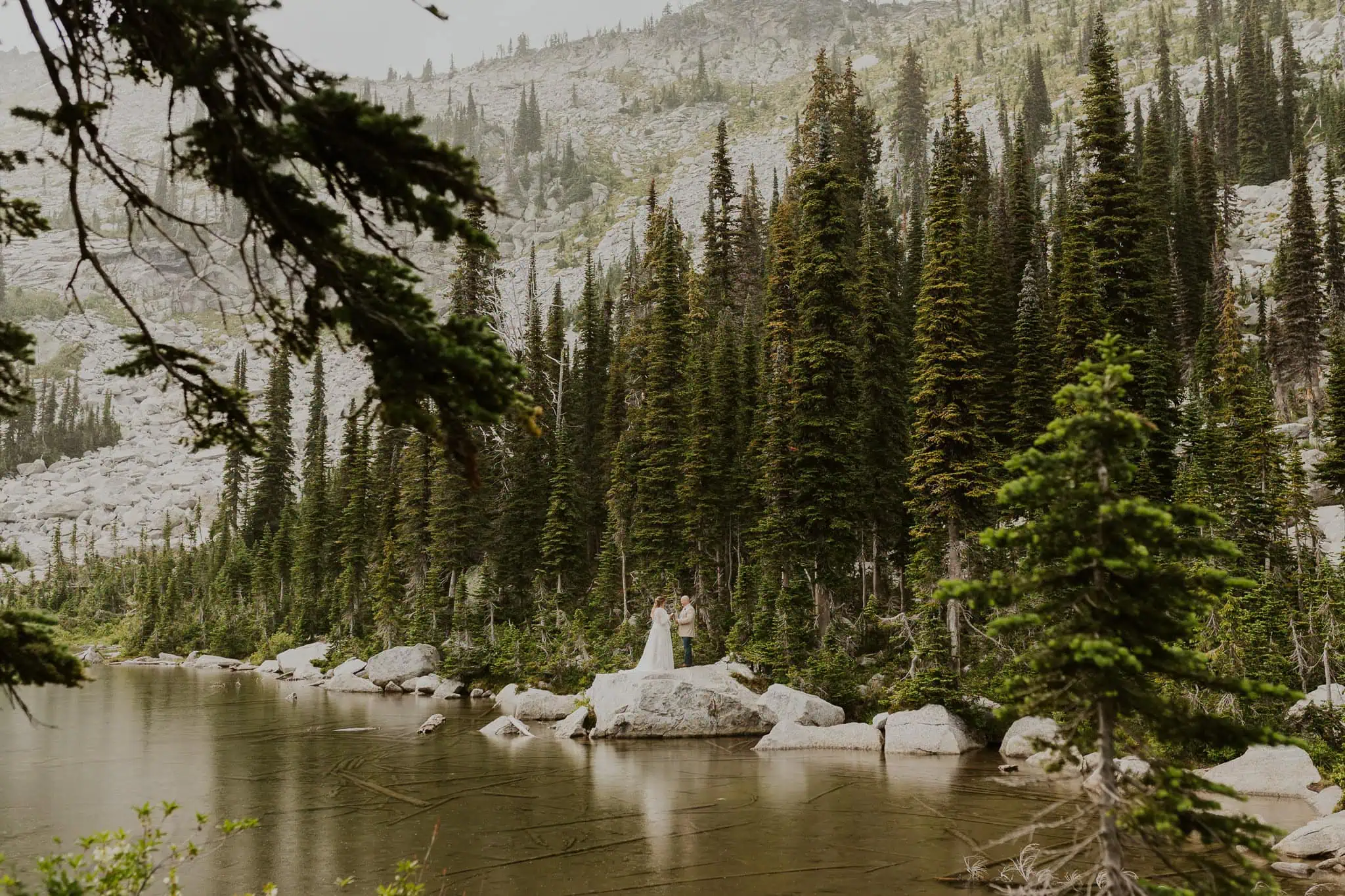 a couple reading vows on a rock in the water for their elopement