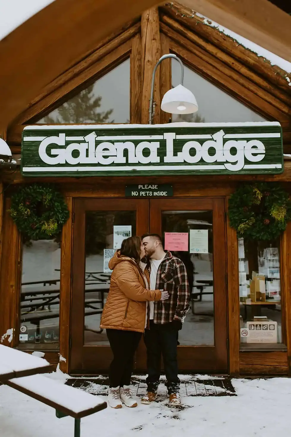couple kissing outside galena lodge in the winter