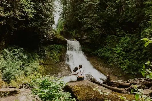 couple sitting at a waterfall