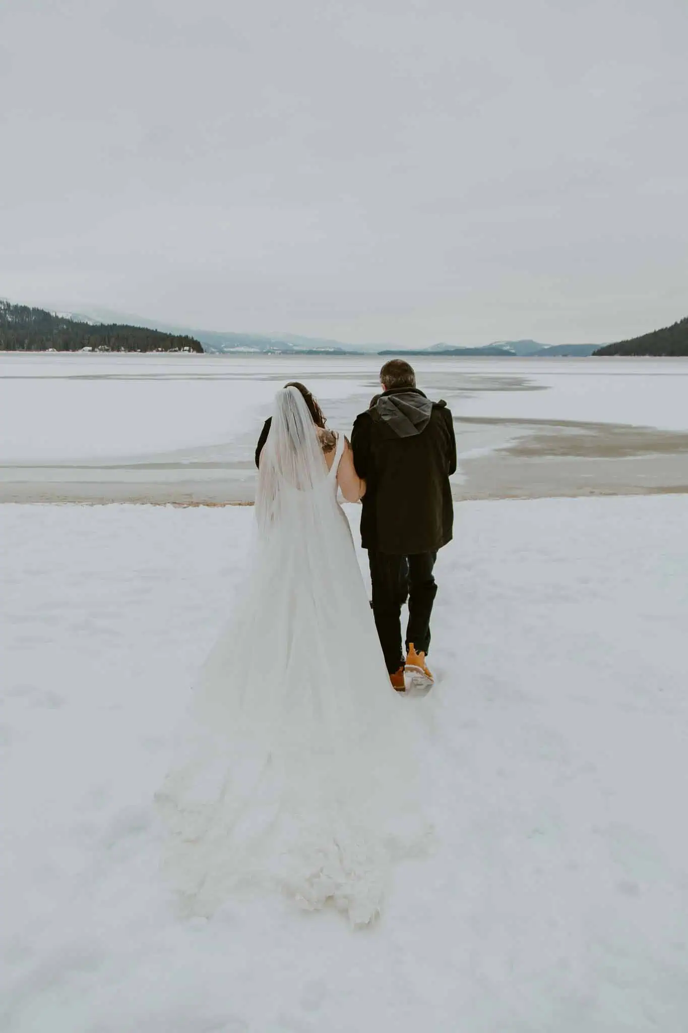 dad walking bride down isle on a snowy beach