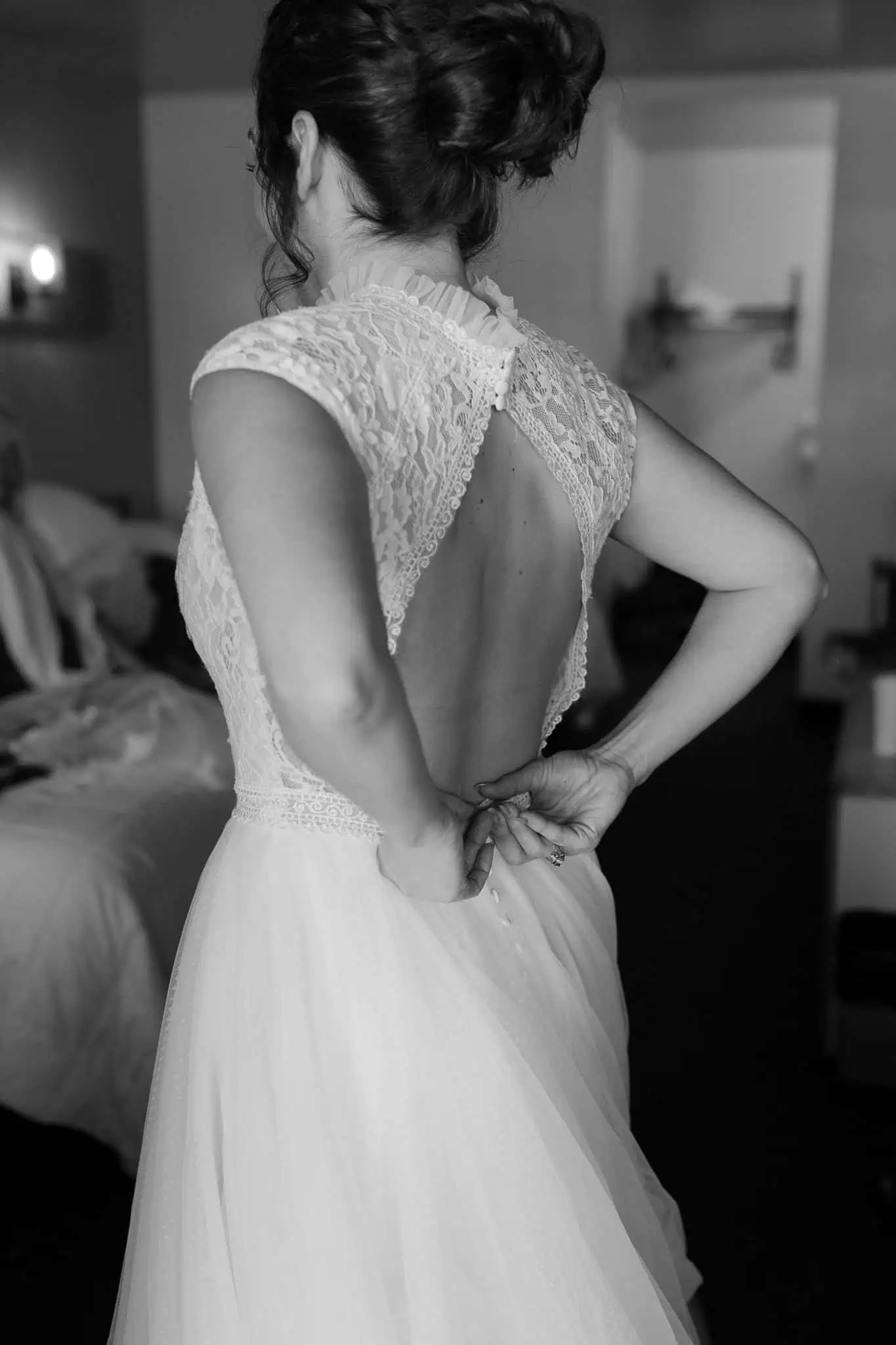 bride buttoning up her dress