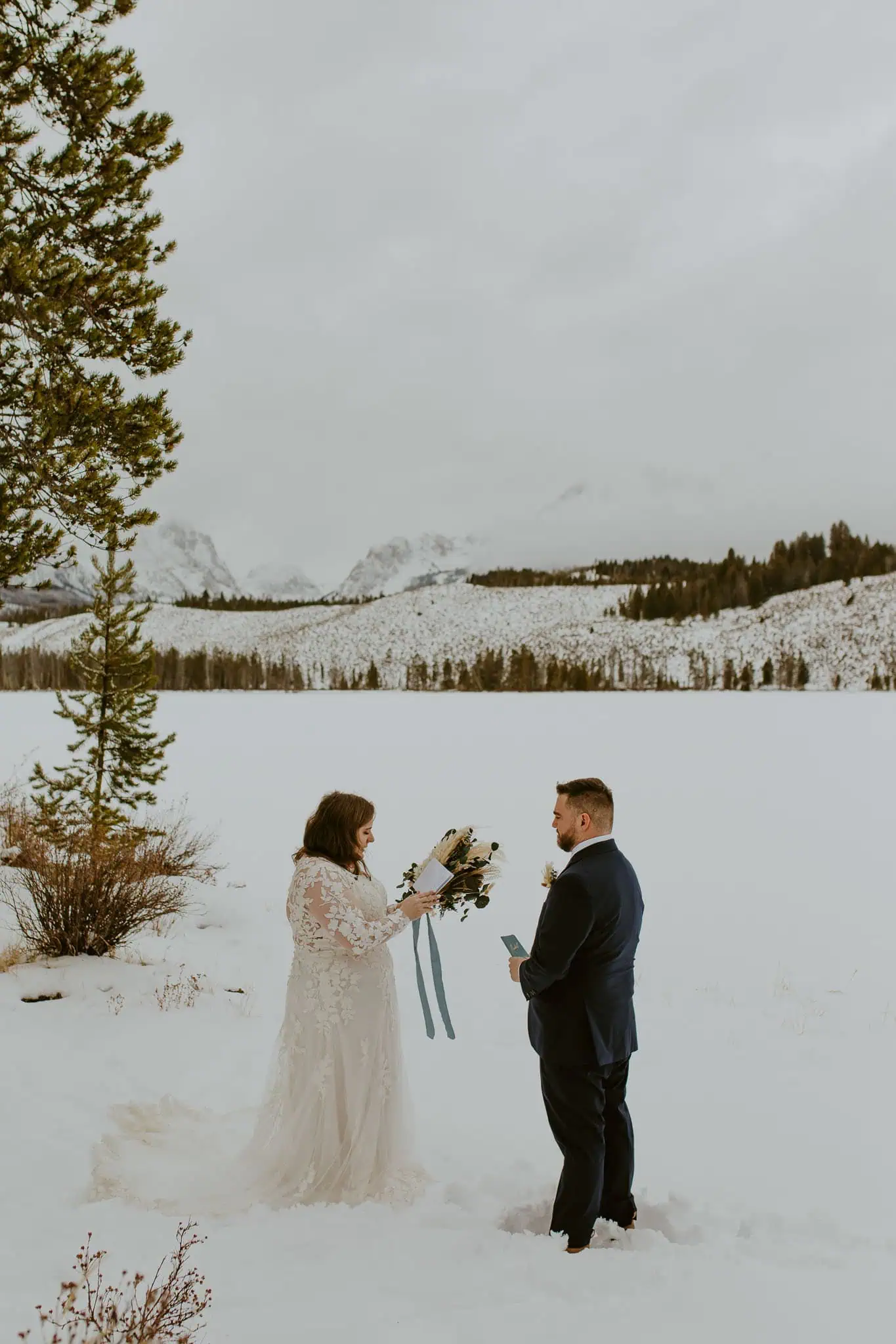 a bride reading her vows to her groom in the snow