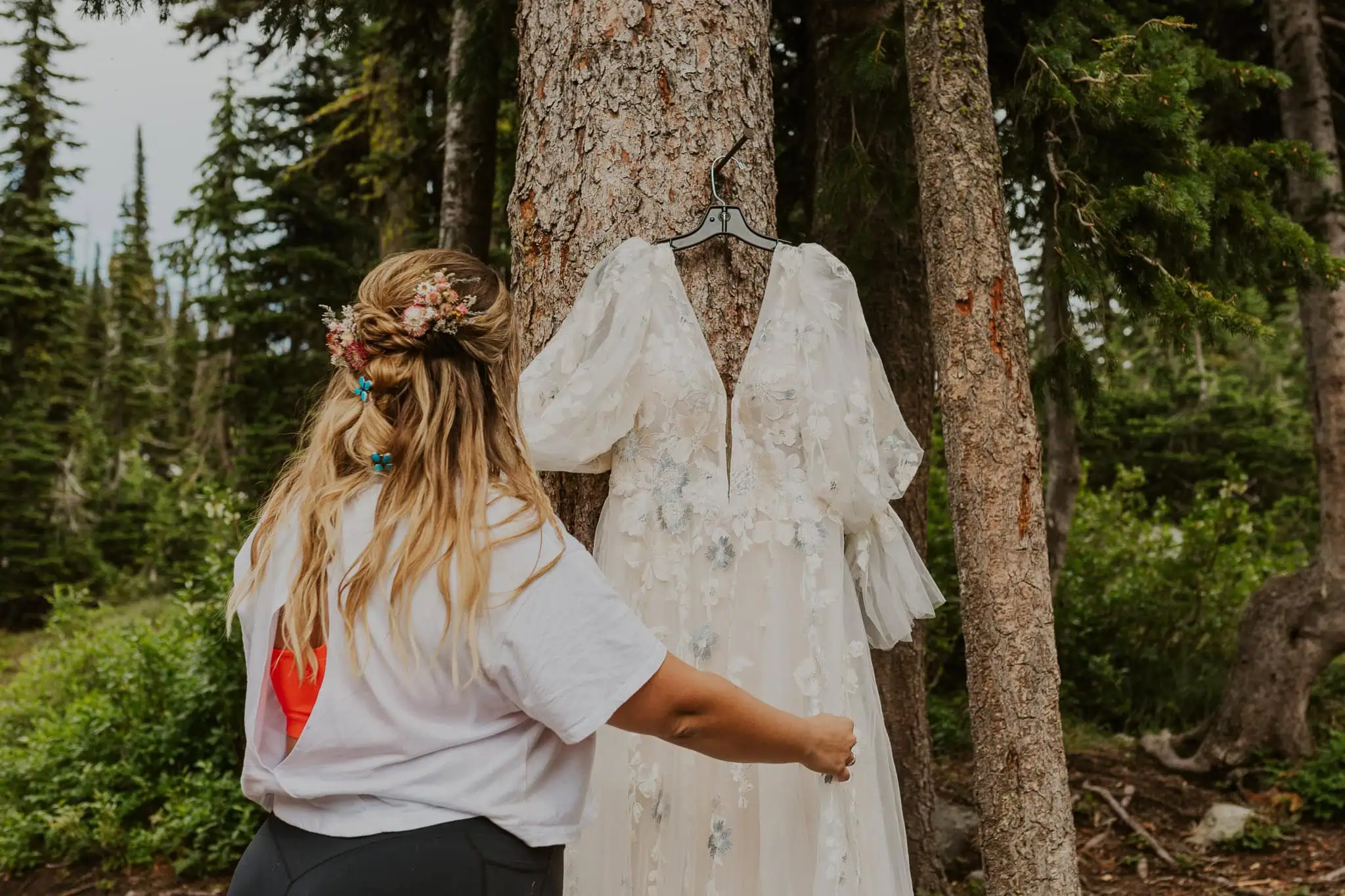 a bride with her wedding dress in the mountains