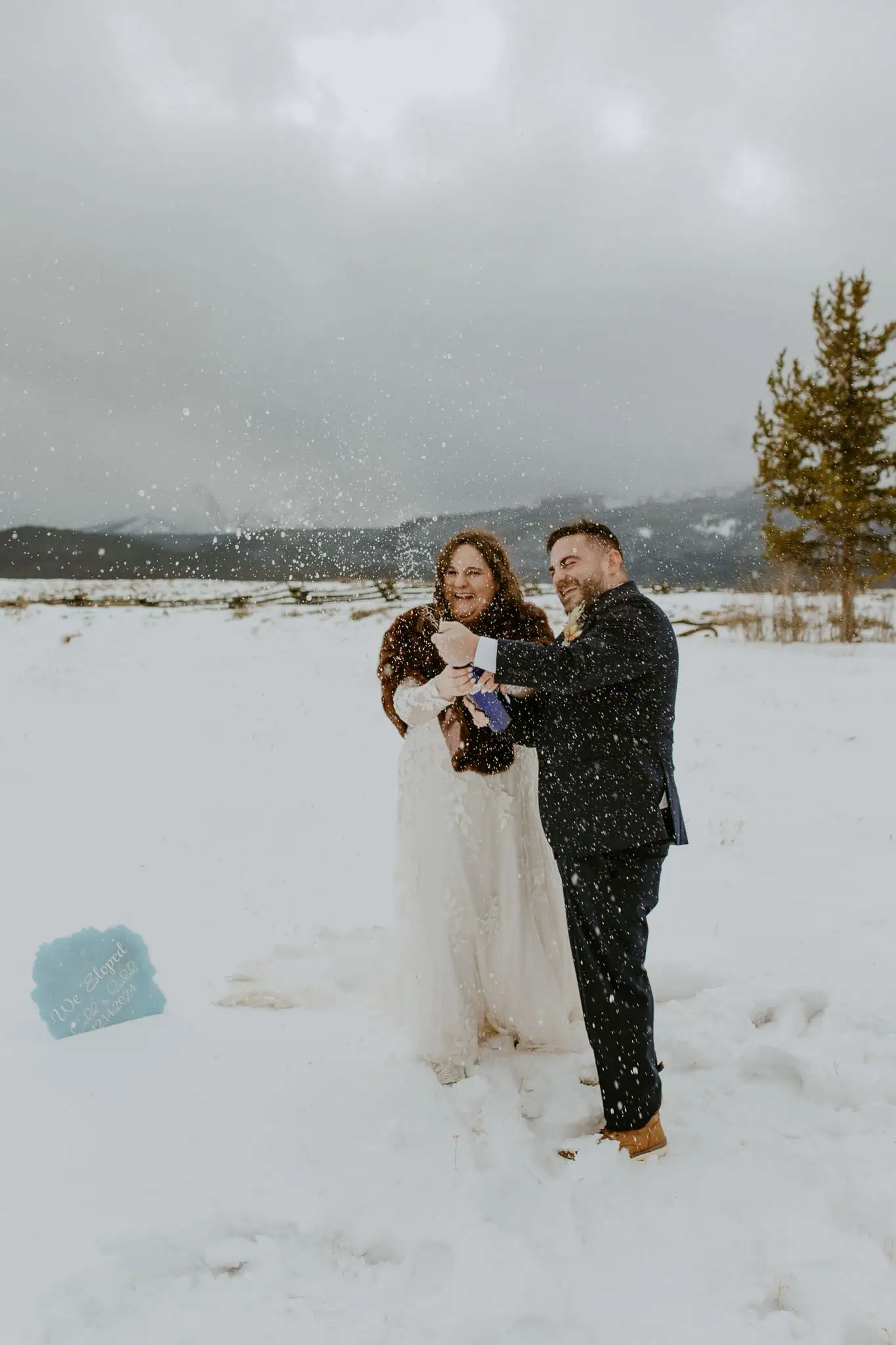 a bride and groom popping champagne after they eloped