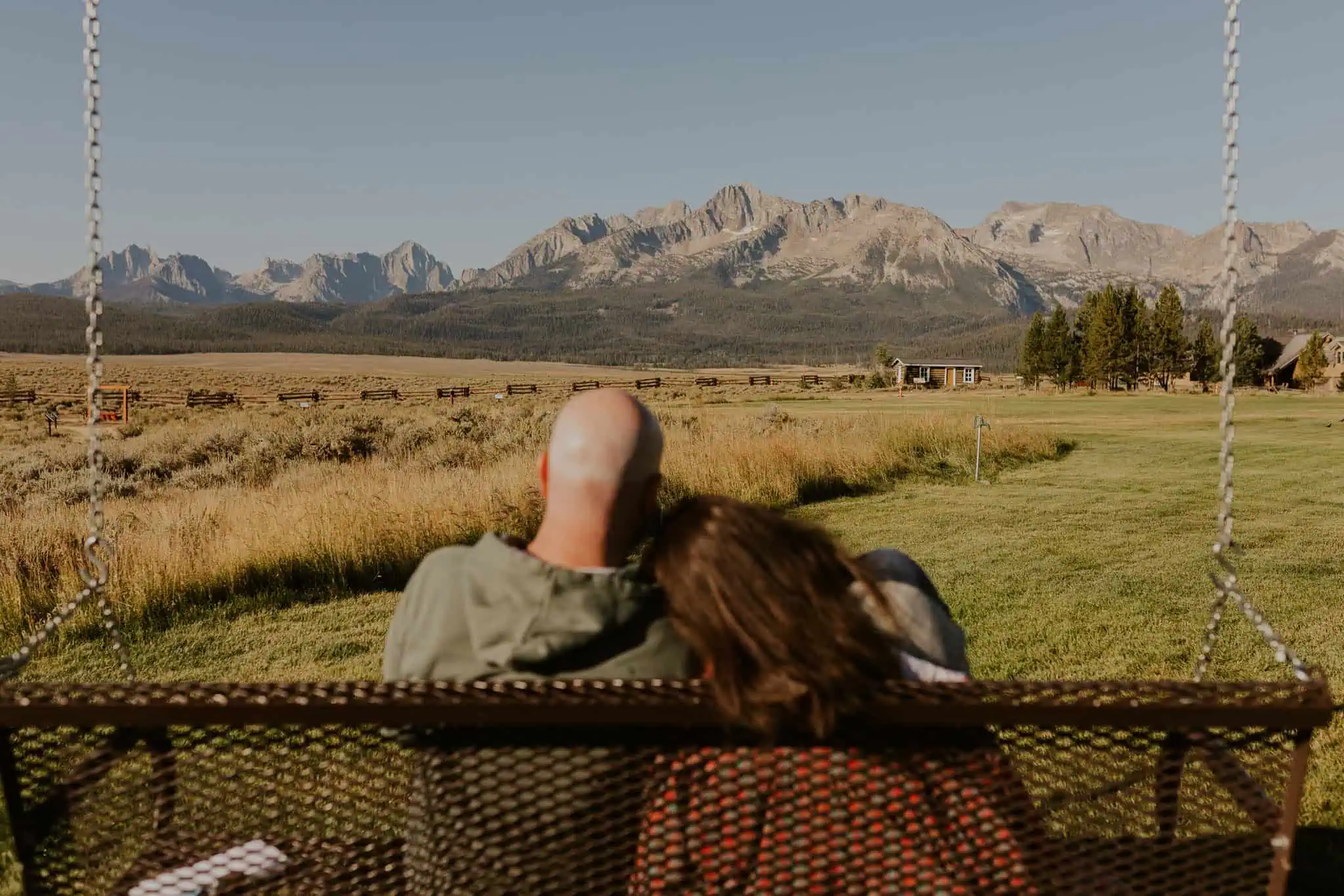 couple sitting on a park swing at pioneer park