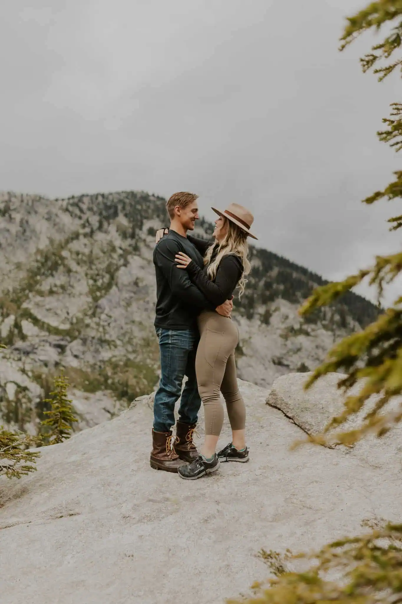 a couple facing each other on a rock