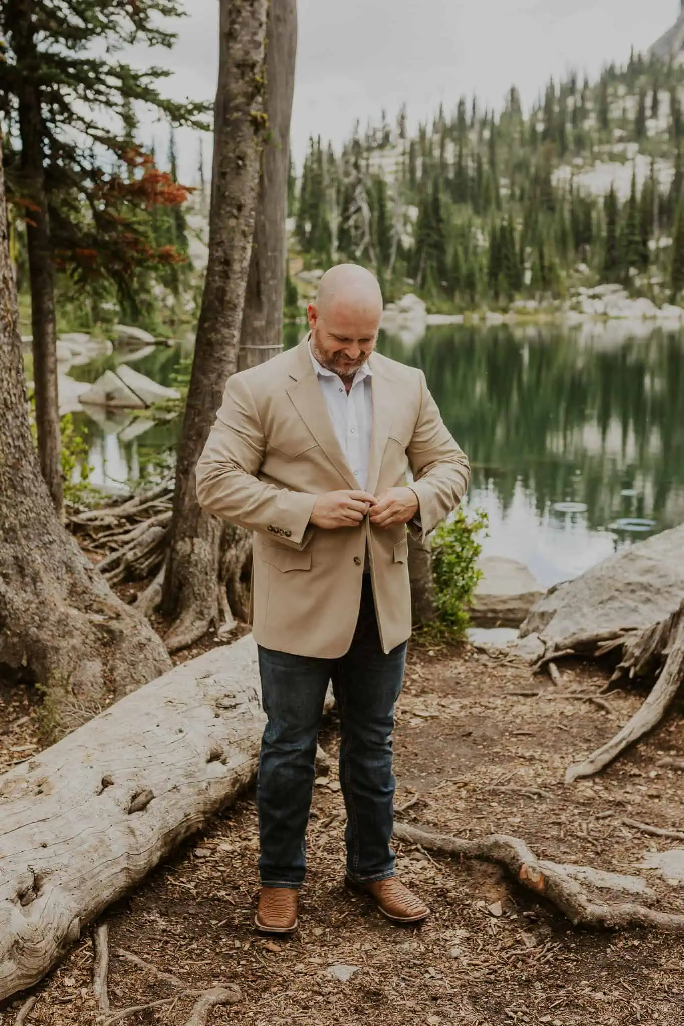 a groom putting on his brown suit jacket