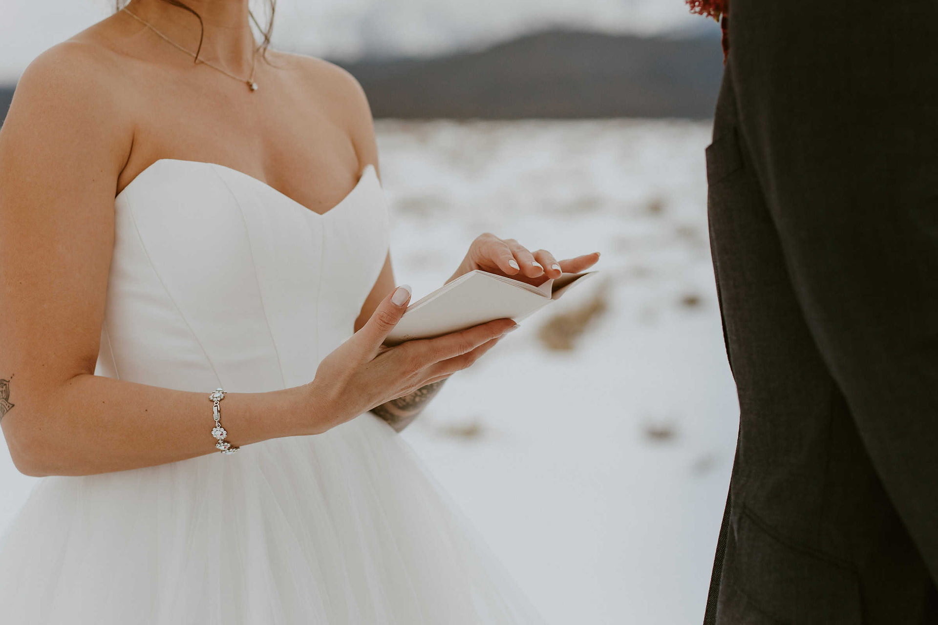 a bride holding her white vow book to read her vows