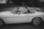 Couple de jeunes mariés heureux en voiture décapotable