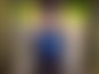 An elderly woman in a wheelchair raises her hands in between a wall as she celebrates.