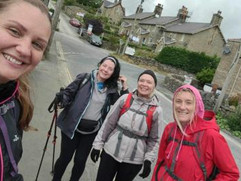 Woman taking a selfie with three other women