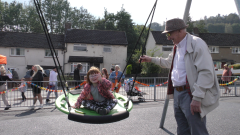grandparent and child on swings
