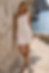 Woman in white lace sleeveless dress by the sea