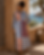 Woman in striped patchwork shirt dress near coast
