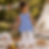 Young girl in blue polka dot top and white pants outside