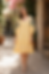 Woman in a yellow floral embroidered midi dress.