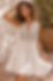 Woman in a white sleeveless boho mini dress with tassels