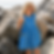 Young girl wearing a blue patterned dress on a rocky beach