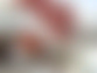 Modern outdoor lounge with beige chairs, red accents, and plants under a white and red staircase. "The Retreat" text on a red wall. Relaxed vibe.