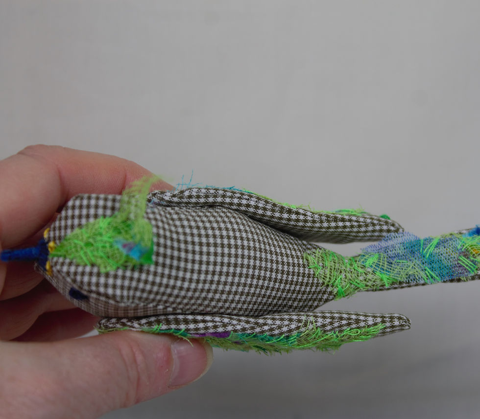 Miniature : Un petit oiseau décoratif en tissus beige et vert vif.