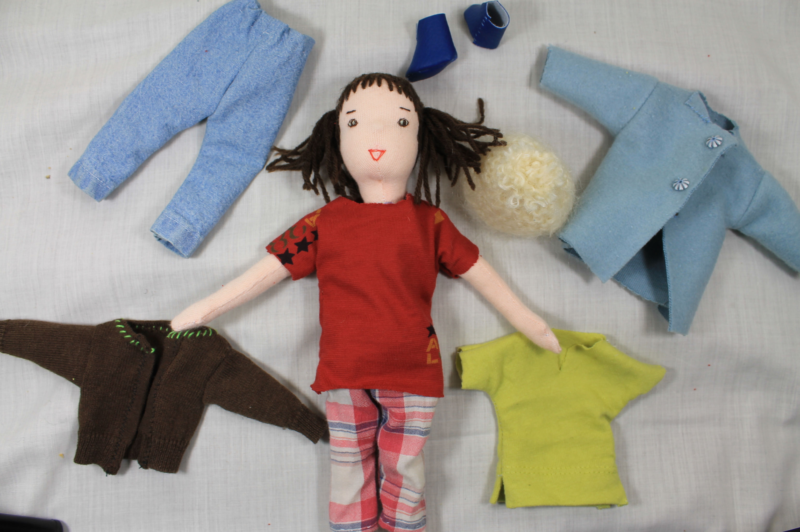 Poupée de chiffon avec garde robe dans son panier.