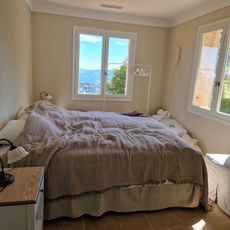 Chambre rénovée avec niches murales et grande fenêtre dans une maison provençale