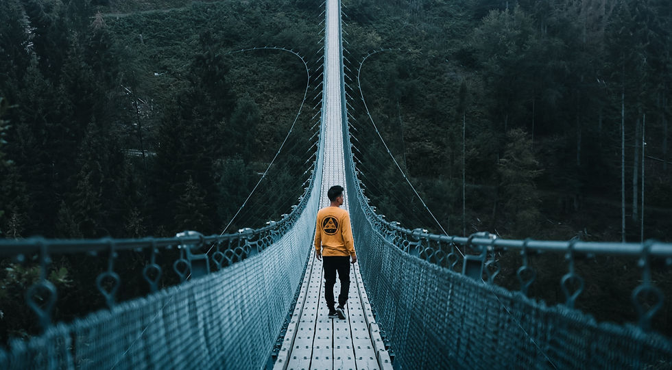 man walking on suspension bridge