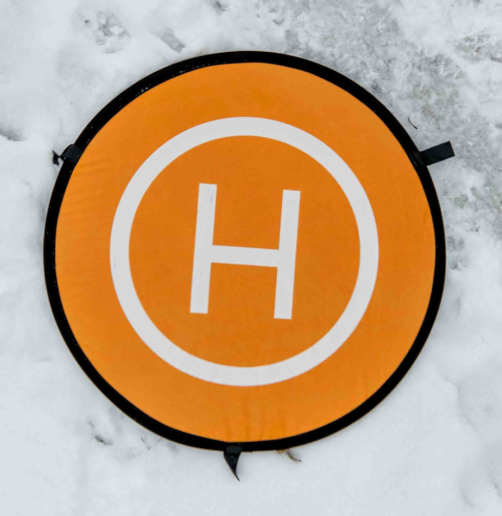 White letter "H" in circle with orange background sitting in snow