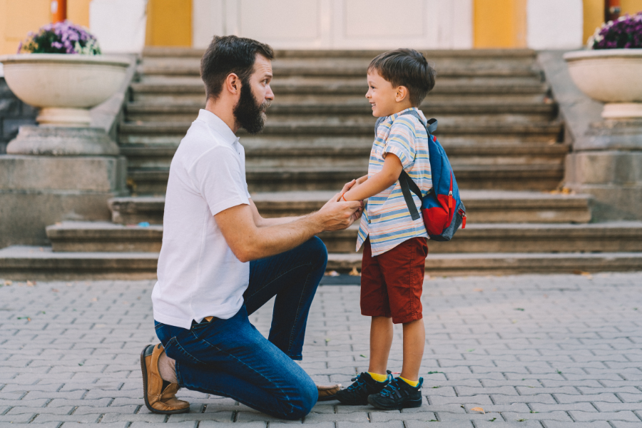 a father crouching down to be eye-level with his son