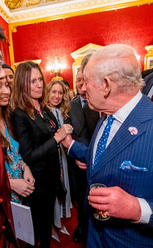 King Charles and Laura WIndsor greet each other with a high-five