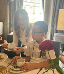 Laura is showing a student the proper way to hold a teacup