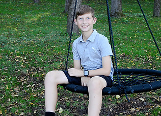 Amanda's son sitting in a swing