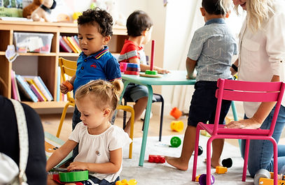 Nursery children playing with teacher in