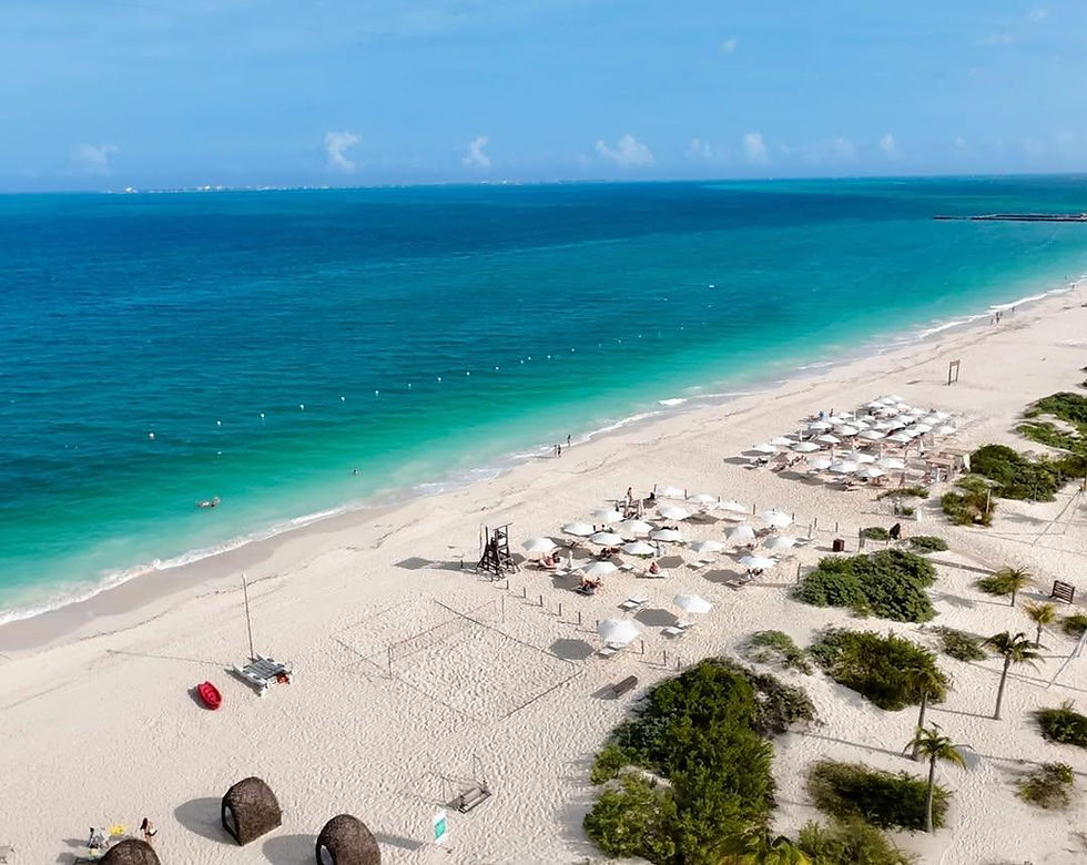 Vista de la playa en Costa Mujeres, con arena blanca y mar turquesa en un ambiente tranquilo y sin multitudes.