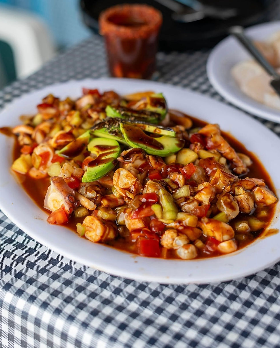 Ceviche mixto servido con aguacate y salsa