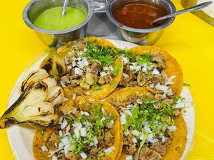 Tacos callejeros servidos en platos sencillos con salsas variadas, en un puesto tradicional del centro de Cancún. Pescado marinado en achiote y naranja agria, cocinado lentamente al estilo tradicional yucateco.