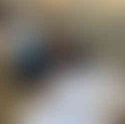 Un elev așezat la birou, privind spre cameră, cu materialele de scris pregătite pe bancă.