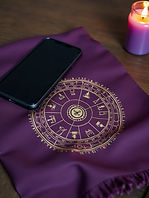 Tissu violet avec carte astrologique, téléphone et bougie
