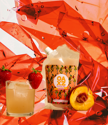 The presentation of the strawberry-peach punch served in an old Fashioned glass with ice and two strawberries placed at the ends of the rim, in a reddish-colored environment confined with whites resembling a plastic cutout arrangement with a touch of a peach cut in half showing the pit giving total freshness