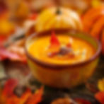 Pumpkin soup surrounded by leaves.