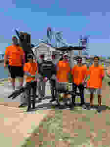 The AATI flight crew pictured with the UAS used during the mission. The custom-built aircraft is roughly 10 feet across in length.