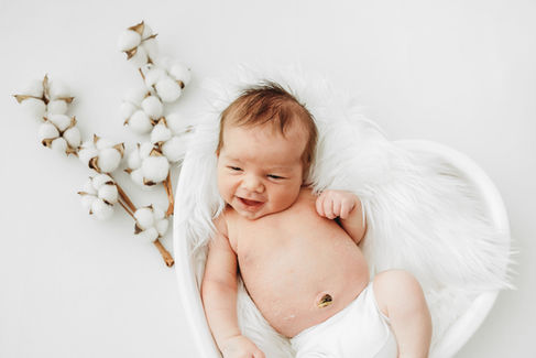 un bébé qui sourit lors de sa séance photo naissance près d'Artenay