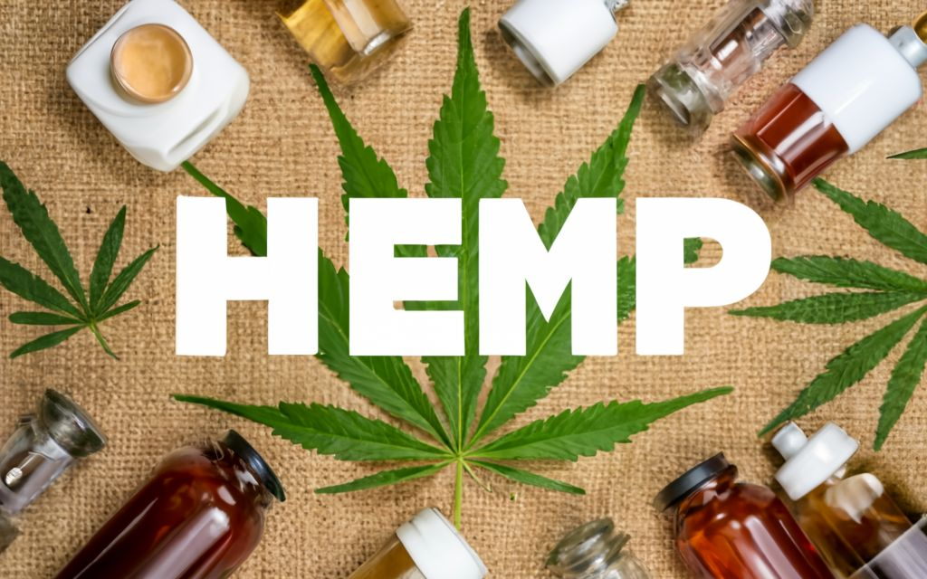 "HEMP " - . background full of hemp leaves. hemp leaf of the hemp plant in the center background, different kinds of hemp products around., typography