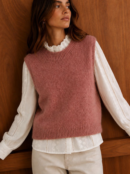 Pull sans manches vieux rose Ycoo à col rond, porté sur une blouse blanche brodée avec un pantalon écru
