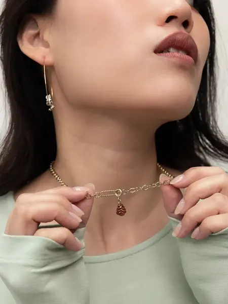Miniature : Charm Pomme de Pin Nach bijou artisanal porté au couBracelet doré avec charms Nach en porcelaine – modèle Pomme de Pin et Coc