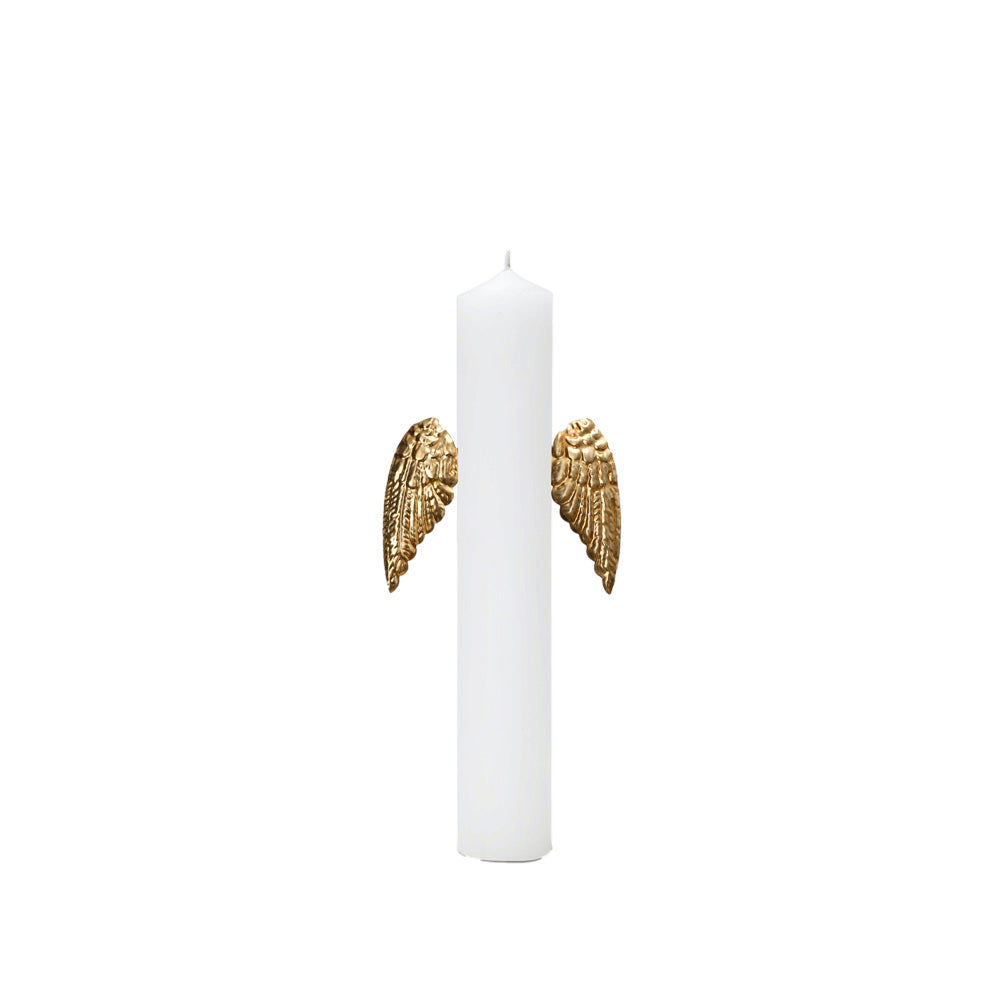 Bijou de bougie en forme de paire d’ailes dorées placé sur les côtés d’une bougie blanche