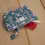 Miniature : Pochette "Albertine Bleu" ouverte laissant apparaître un peigne rouge et un tube de maquillage