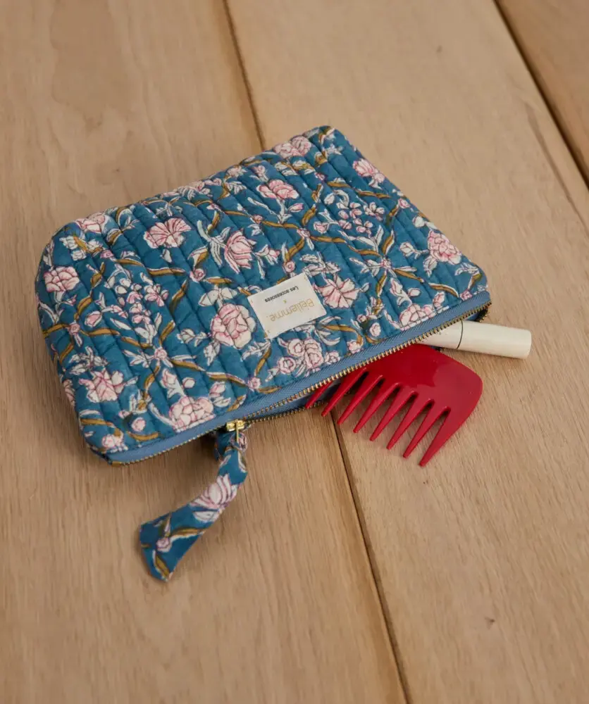 Pochette "Albertine Bleu" ouverte laissant apparaître un peigne rouge et un tube de maquillage