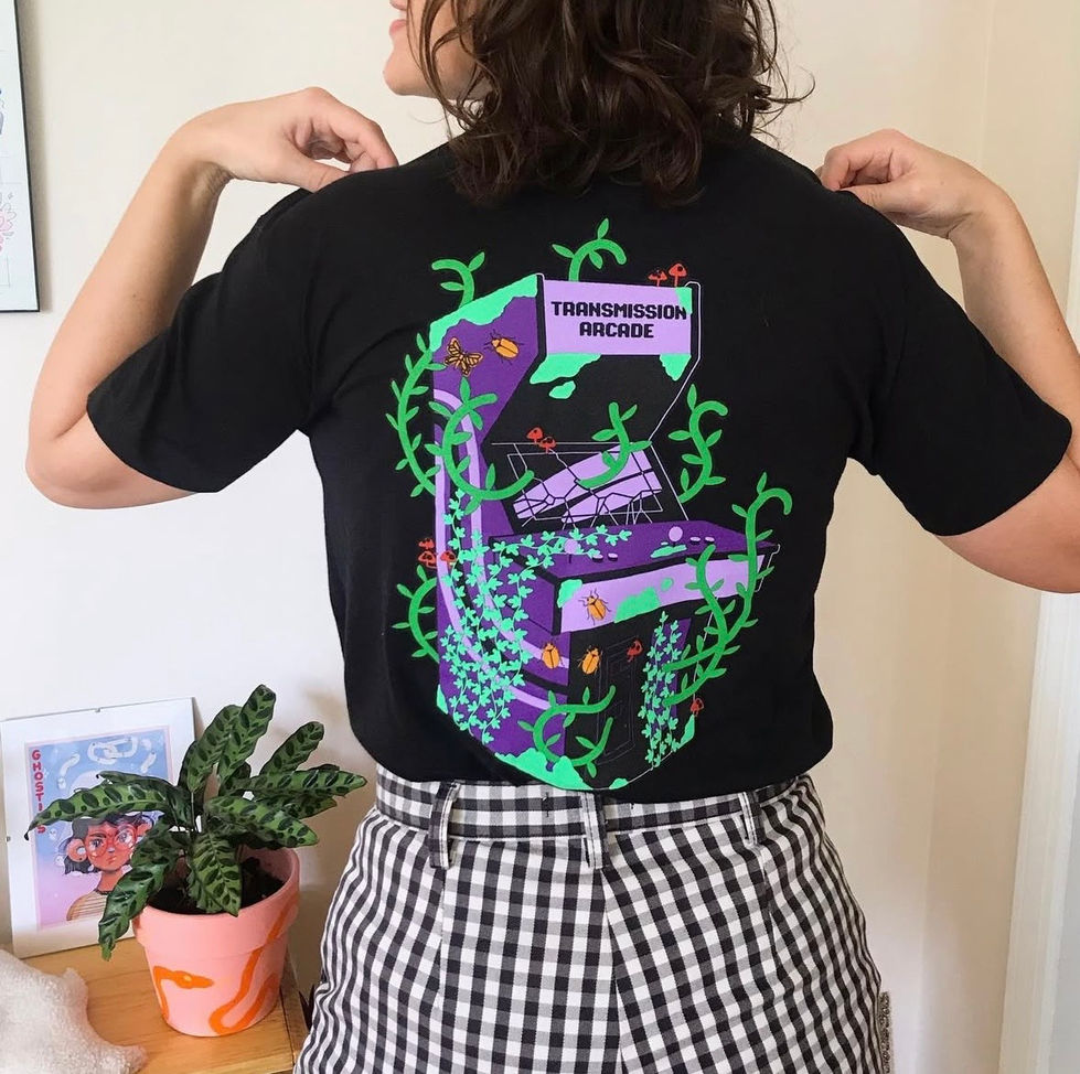 A girl wearing a black shirt. The back has a pinball machine illustration by Rachel Sullivan Illustration